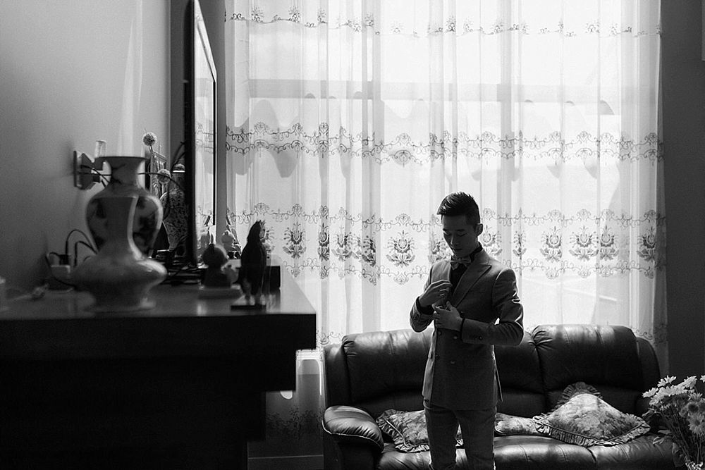 Moody black and white interior shot with light streaming through lace curtains.