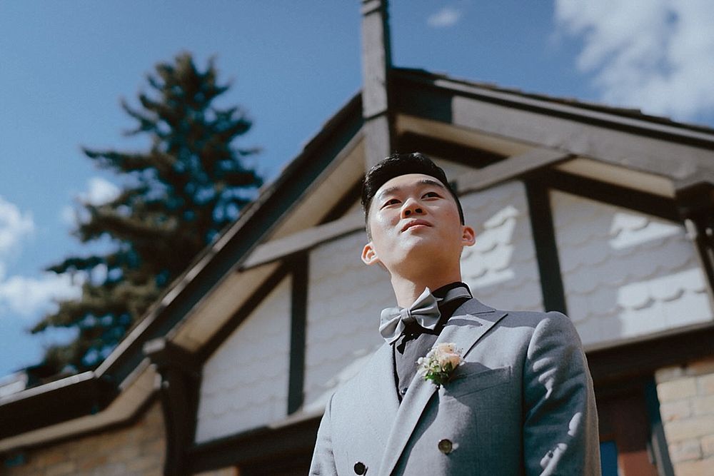 Wedding venue exterior shot with blue sky and evergreen trees in the background.