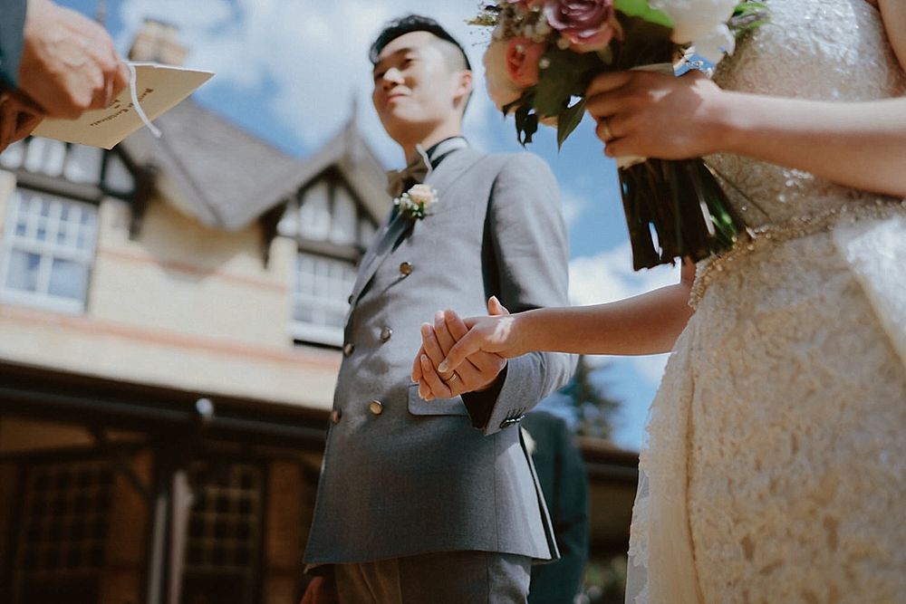 Close-up wedding ceremony moments captured outside a rustic venue.