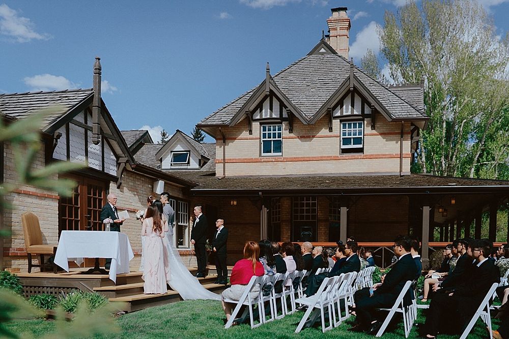 Wide shot of wedding venue exterior with white chairs set up for outdoor ceremony.