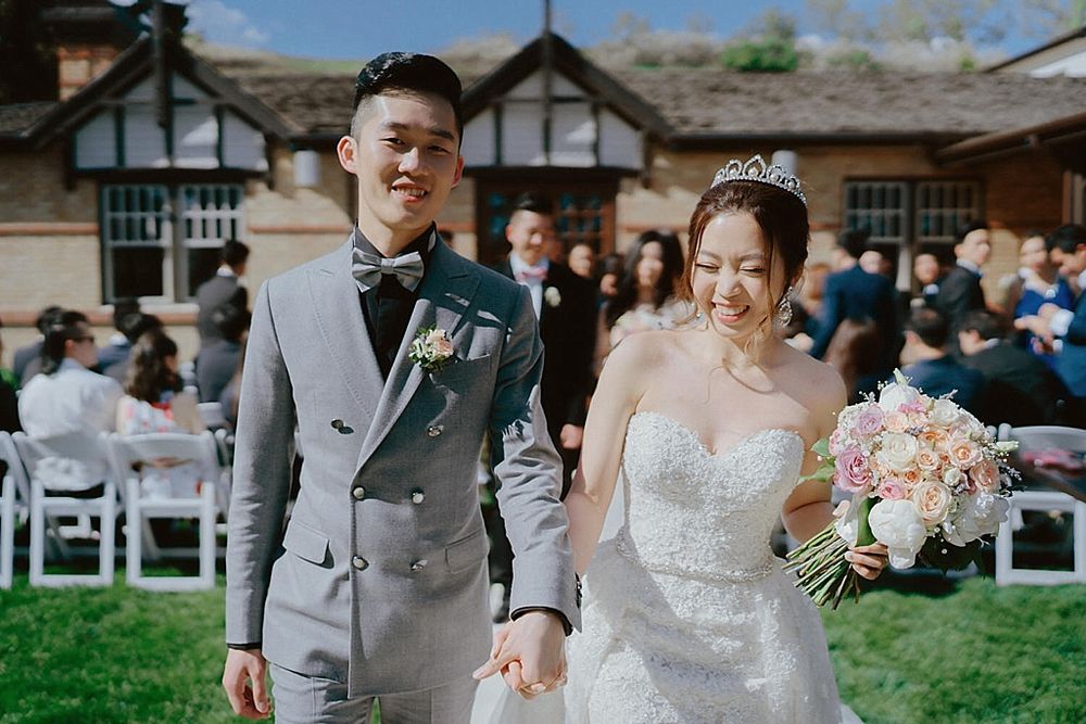 Wedding ceremony in progress at an elegant outdoor venue with garden setting.