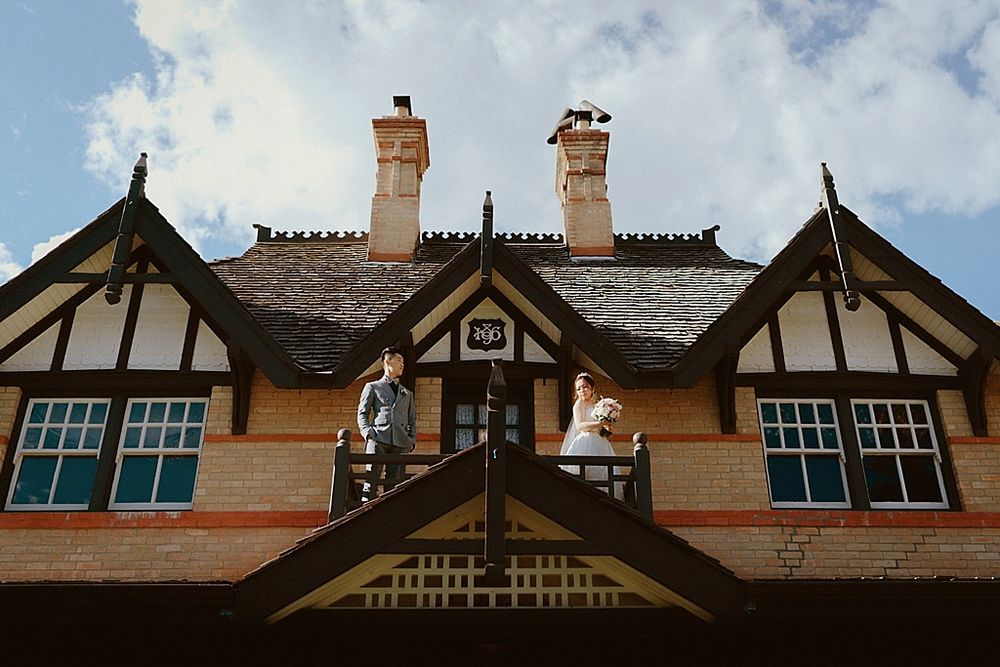 A Tudor-style building exterior with ornate chimneys and architectural details against a blue sky.