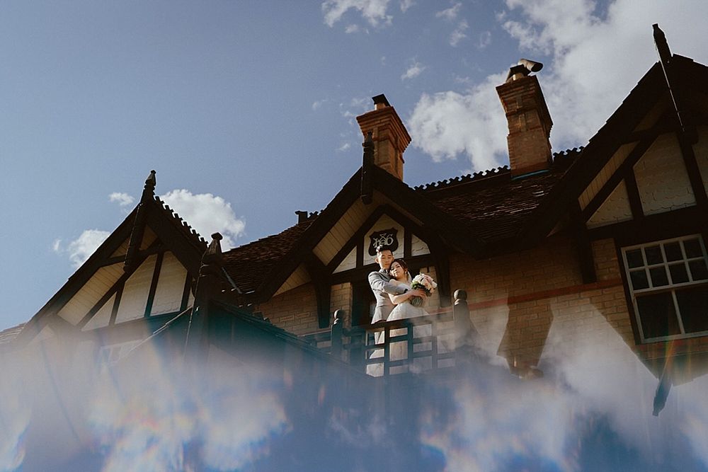 Low-angle view of a vintage Tudor building facade with decorative timberwork against clouds.