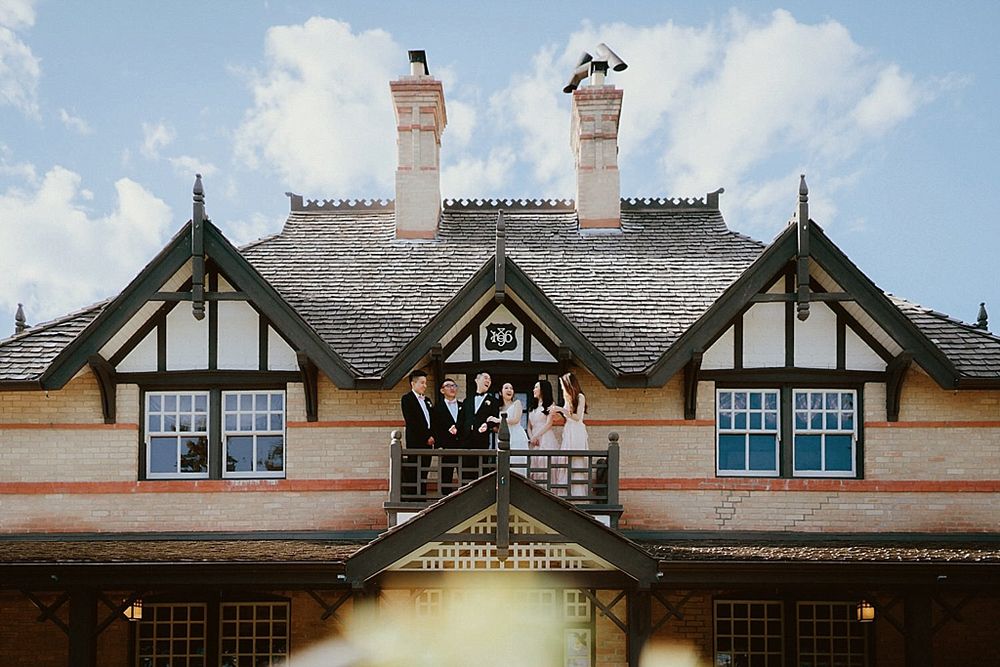 Wide-angle shot of Tudor mansion's roofline featuring traditional architectural elements.