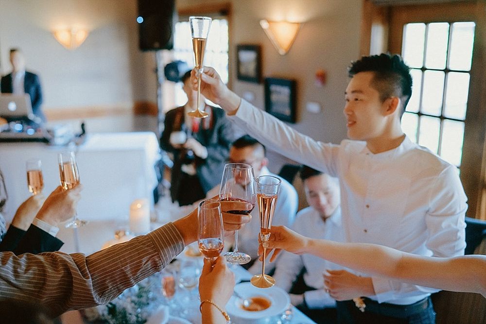 Wedding guests raising champagne glasses for a celebratory toast.