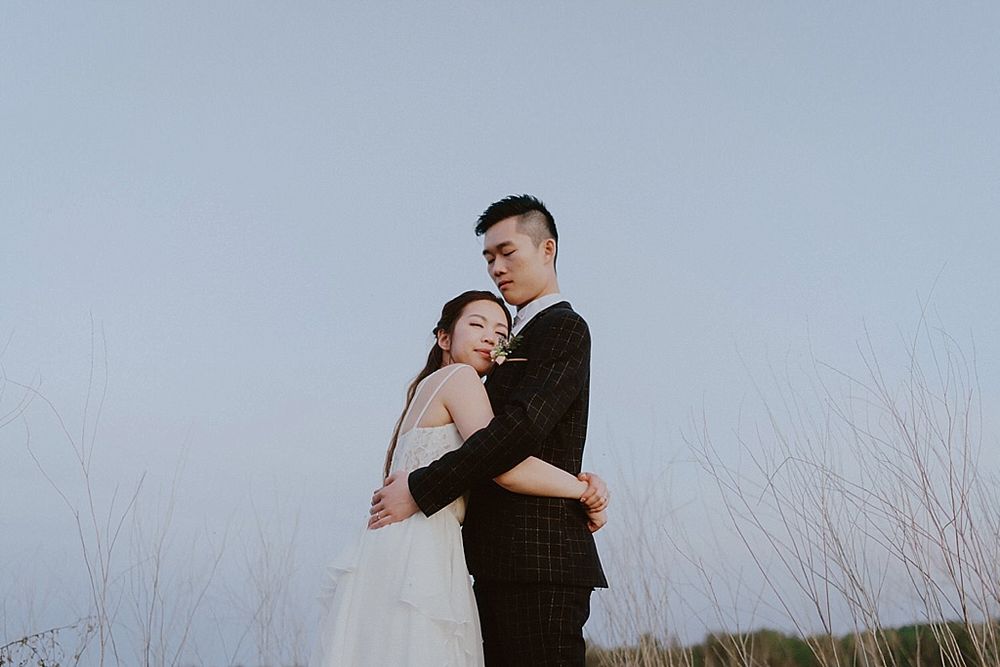 Black and white romantic portraits of a couple on their wedding day against a light background.