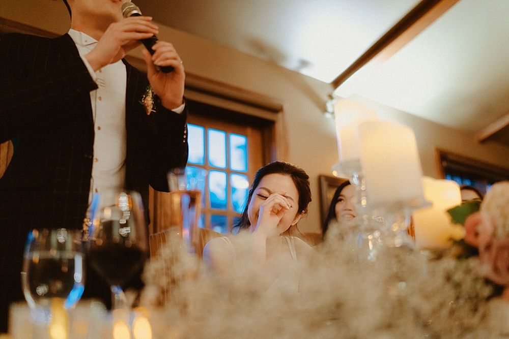 Guests celebrating at an elegant wedding reception with rustic lodge-style decor and lighting.