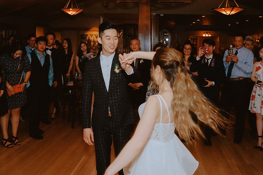 Guests celebrating at an elegant wedding reception with rustic decor and ambient lighting.