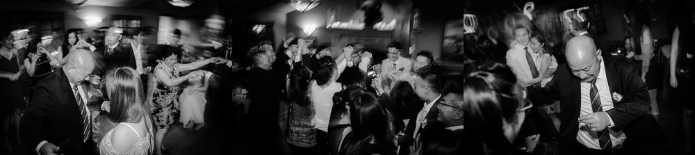 Blurred motion captures dancers moving at a dark reception venue.