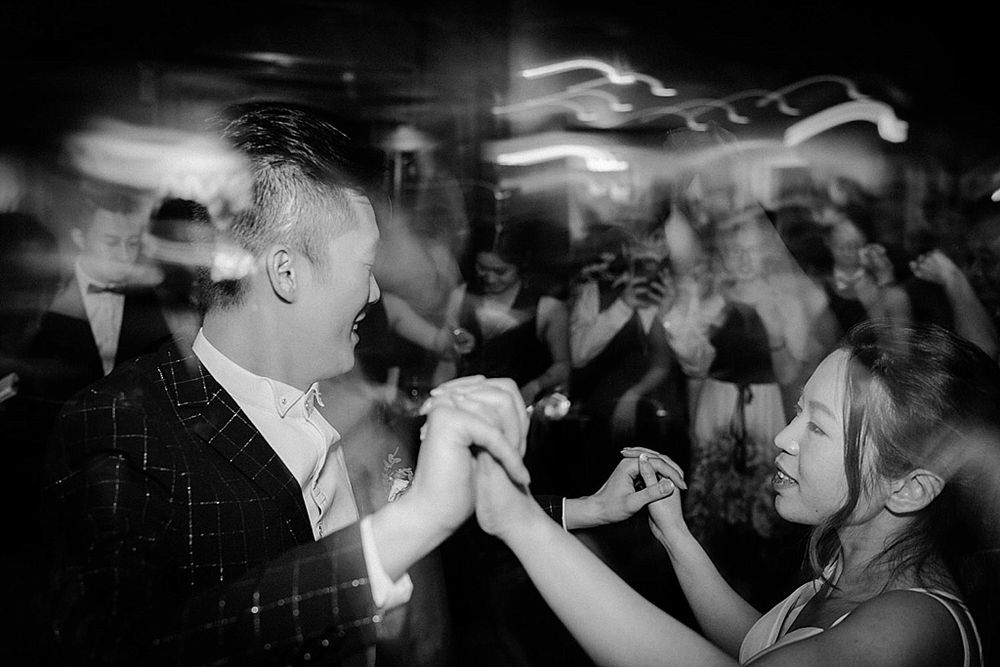 Black and white photo showing dancing couples on a crowded reception floor.