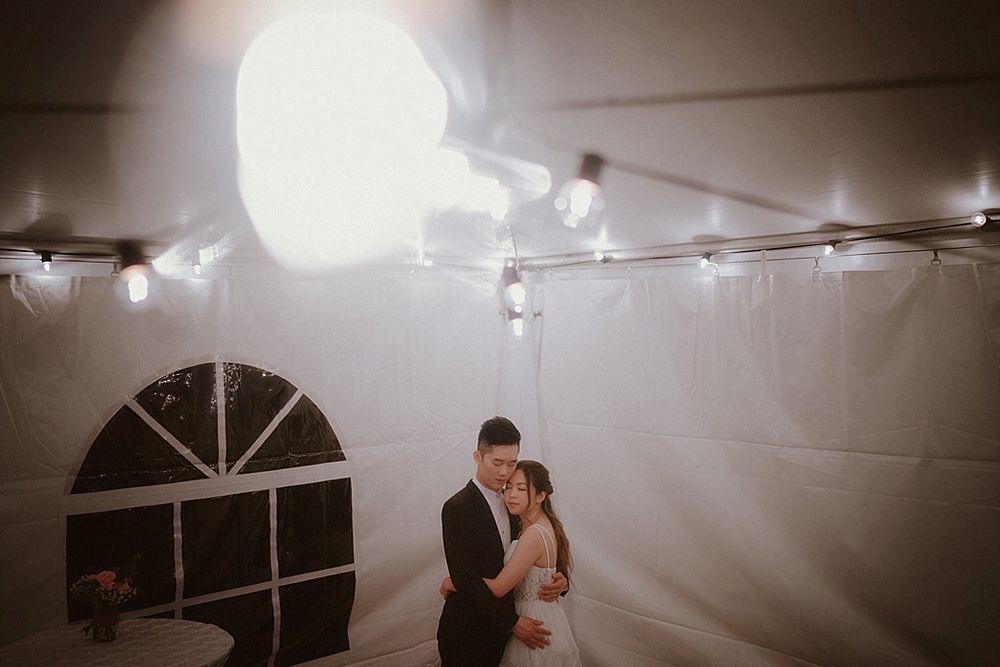 A romantic dance under string lights in a dimly lit room during a wedding reception.