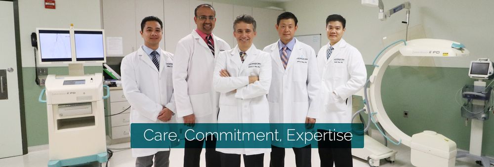 Medical team of vascular specialists in white coats standing in front of medical equipment.