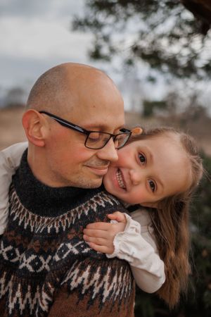 Candid outdoor photo of sweet family moment captured in warm natural lighting.