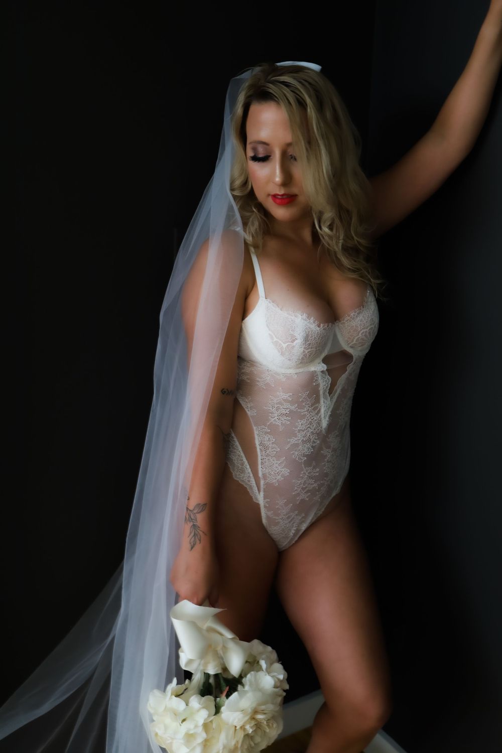Bridal boudoir photos featuring white lace lingerie and veil.