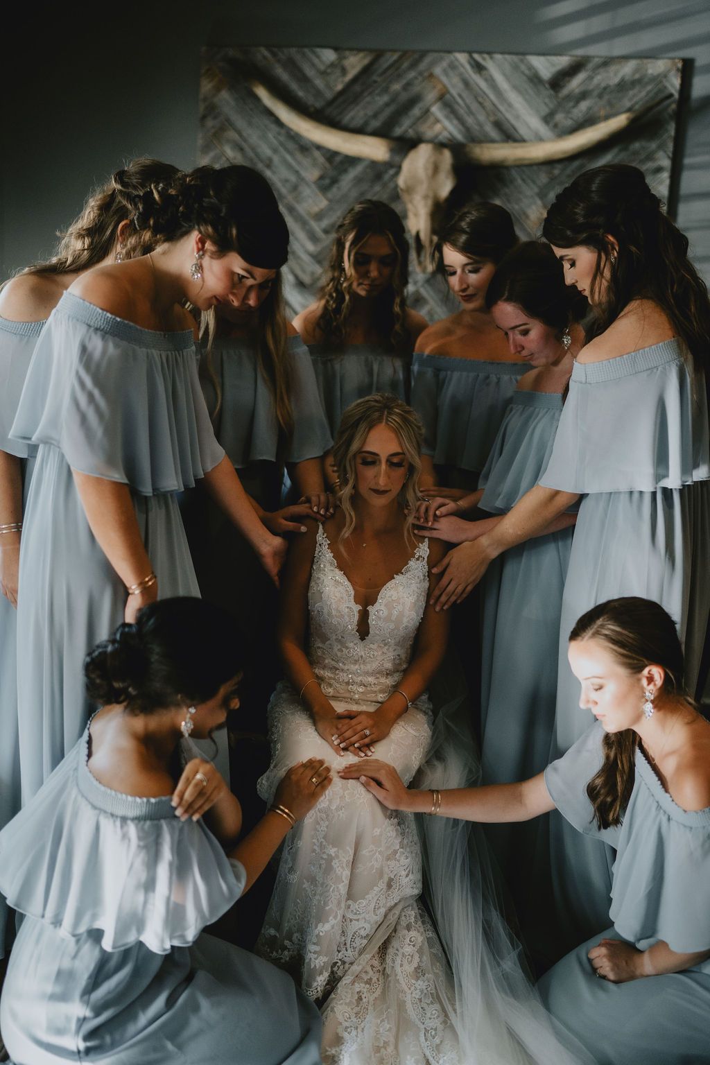 bridesmaids praying around bride