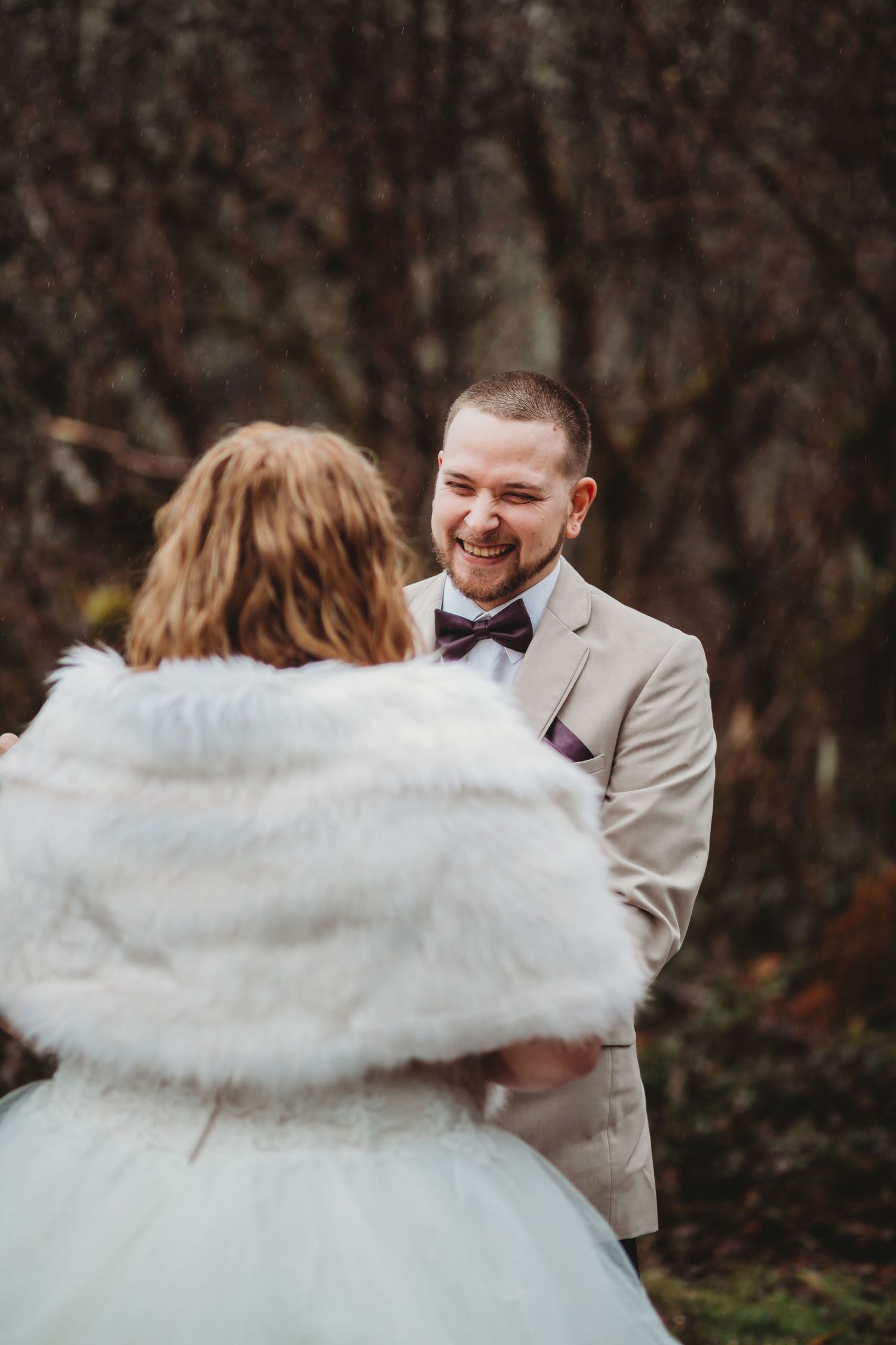 A groom laughs during his wedding vows at a Washington lakeside elopement.