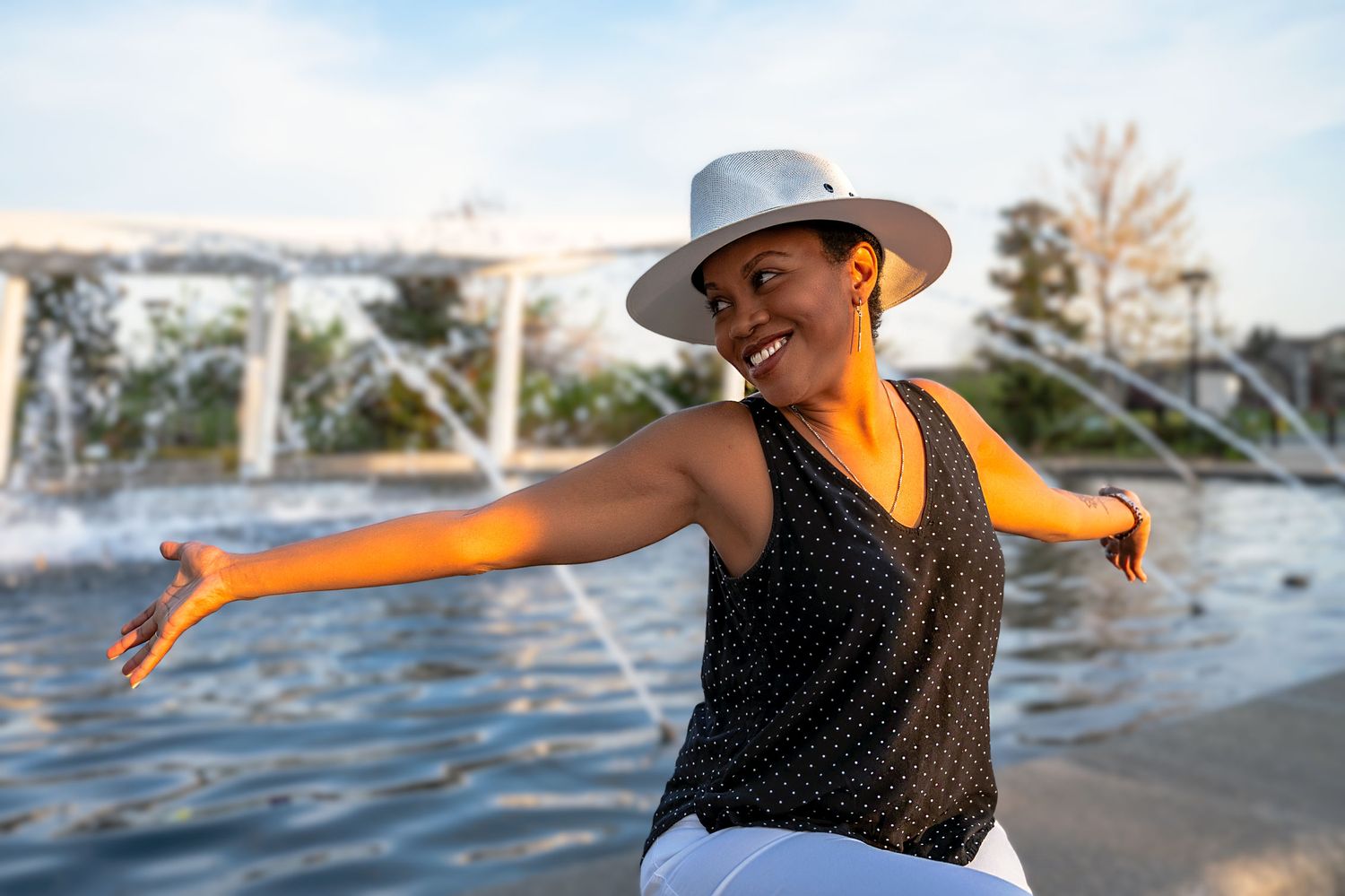 Female sitting next to a fountain.
