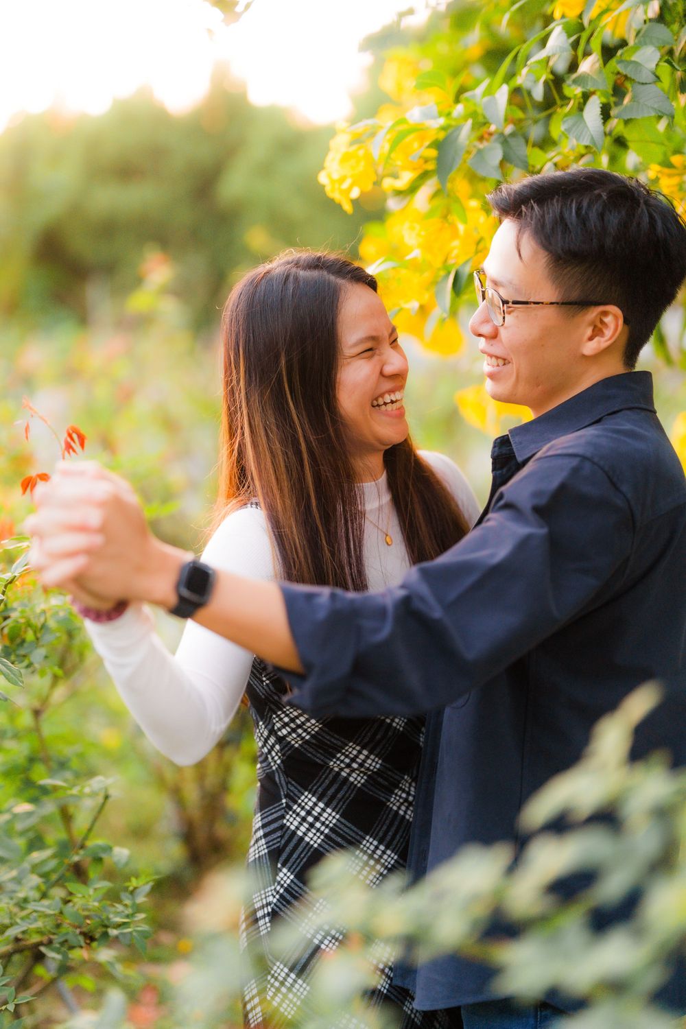 A couple dances together among yellow autumn leaves in warm sunset light.