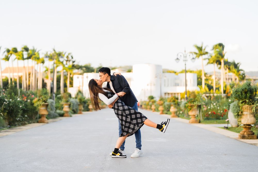 A playful couple doing a romantic dip pose while dancing outdoors.