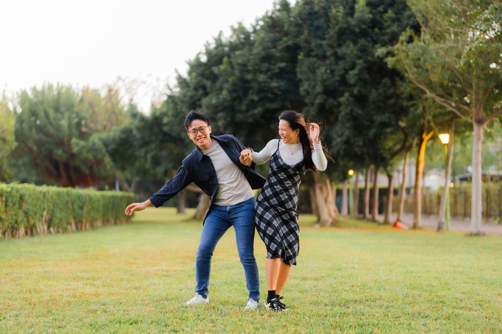 Happy couple playing and dancing together in a park setting.