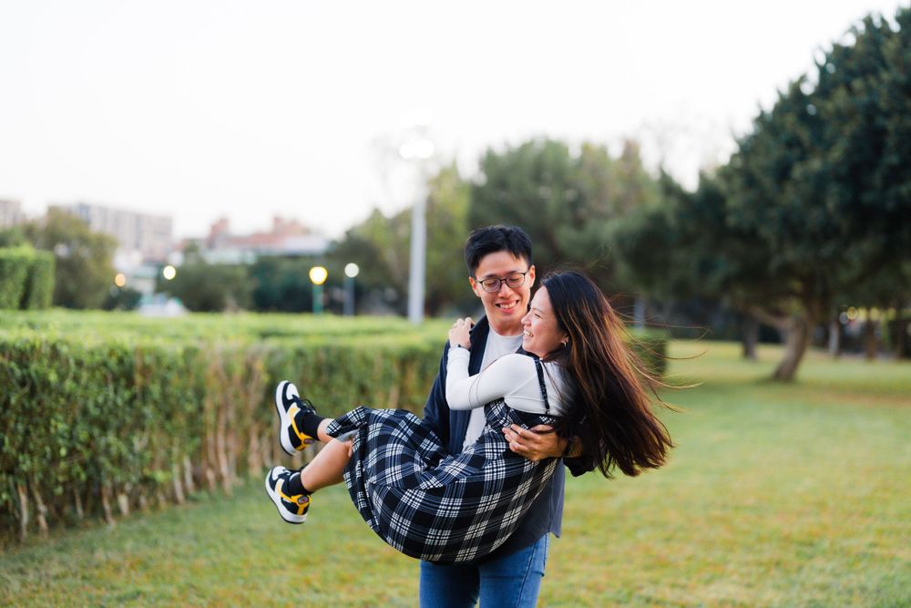 A playful piggyback ride moment captured in a garden setting.