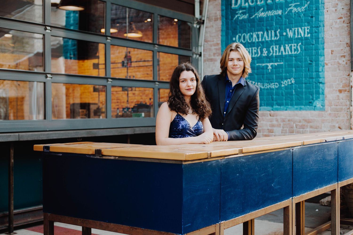 A modern cocktail bar setting with industrial decor and blue wooden details.