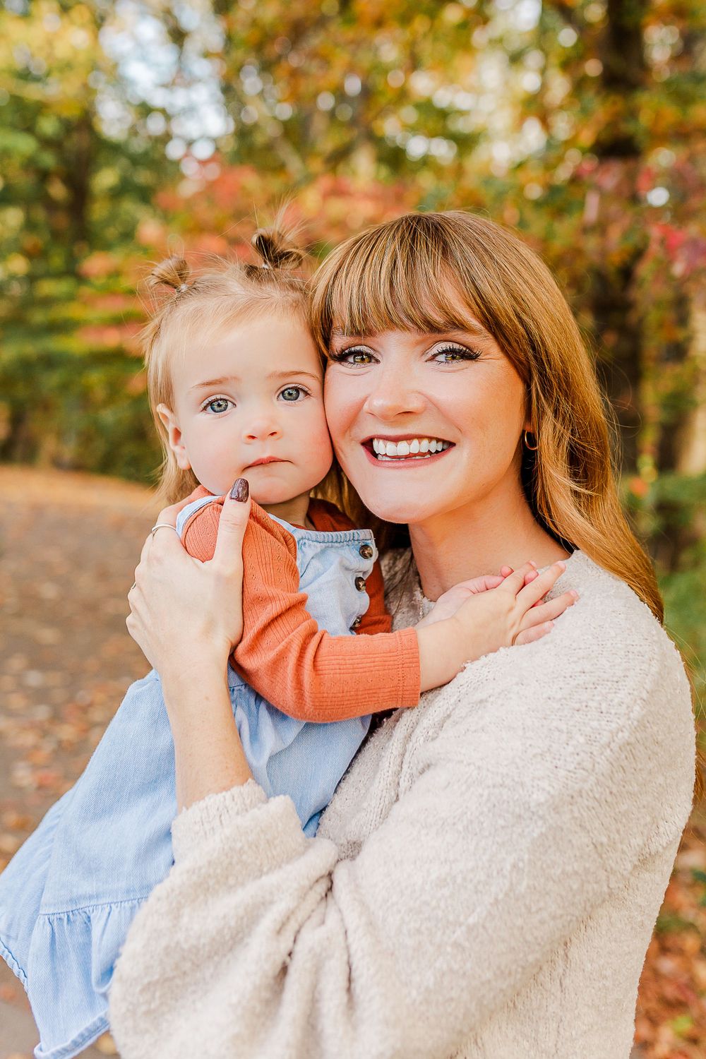 Close-up portrait of parent and child outdoors in autumn setting.