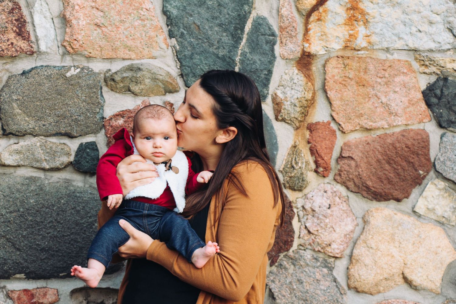 A tender moment captured against a stone wall background.