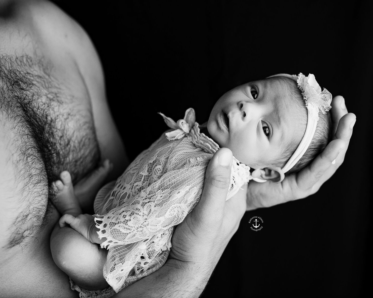 daddy daughter newborn pictures Riverside CA, black and white photo of newborn girl being held in dad's hands