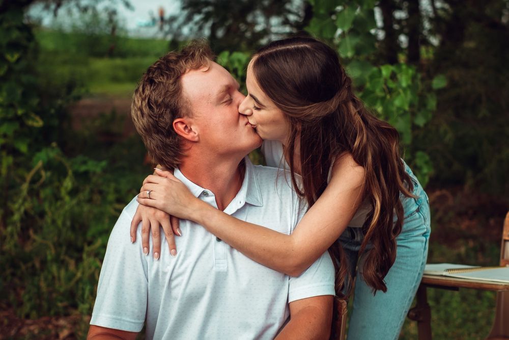 Romantic Engagement photo of couple celebrating their engagement with a kiss