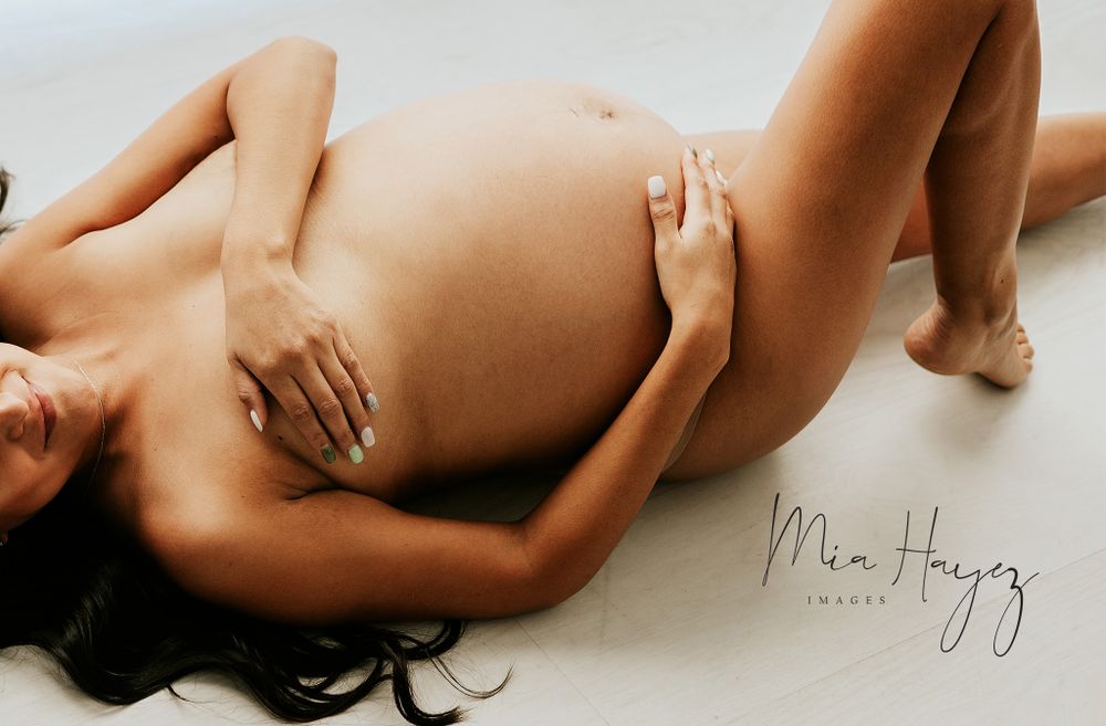 Artistic maternity boudoir photography with minimalist nude silhouette poses.