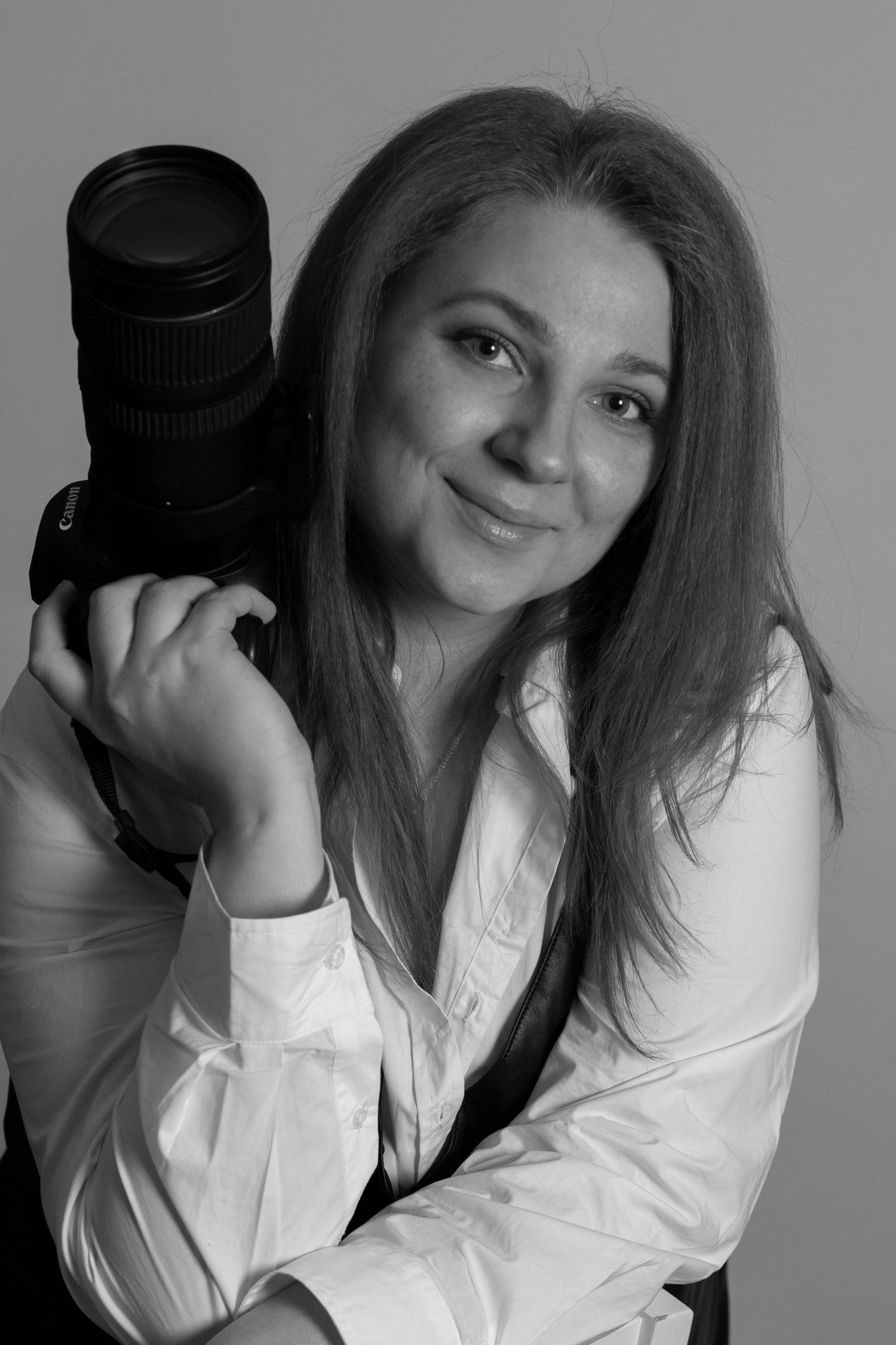Xenia Helix, talented photographer, holds camera in captivating black & white portrait
