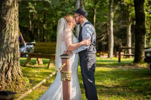 Romantic outdoor wedding moment between couple in woodland setting.