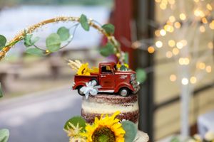 Wedding dessert table with vintage red truck decoration and sunflower accents.