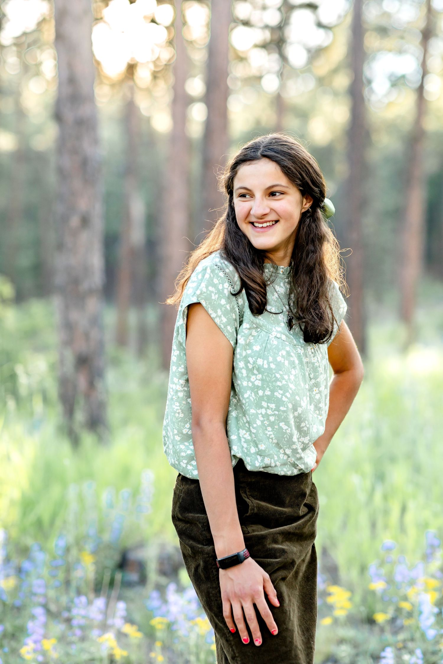 Teen girl poses with one hand on her hip smiling to the side during their family session in Colorado Springs.