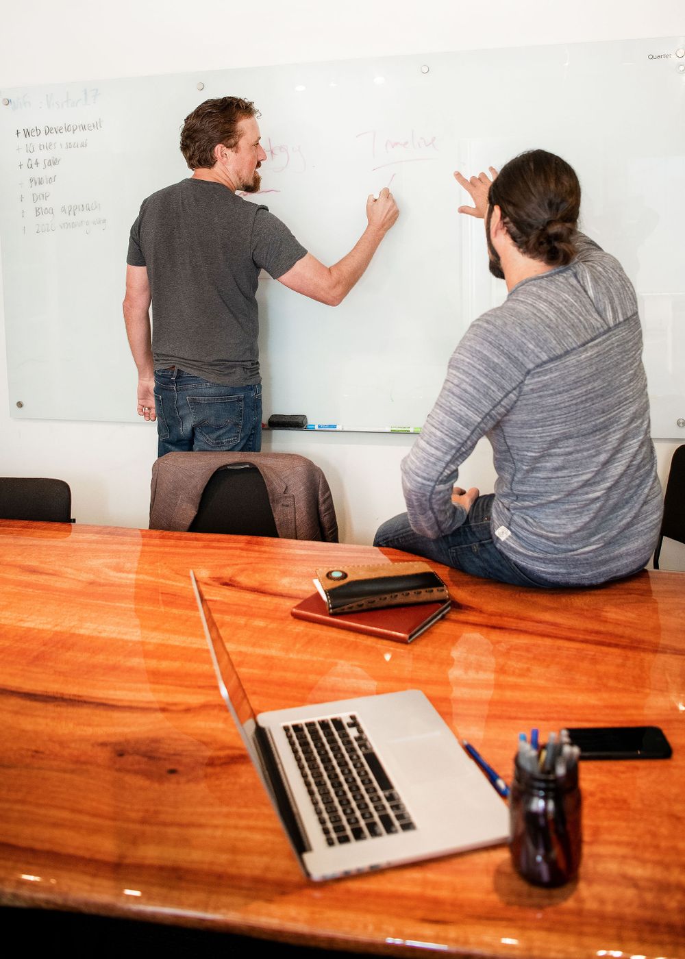 office meeting in a casual office space with a man writing on the white board