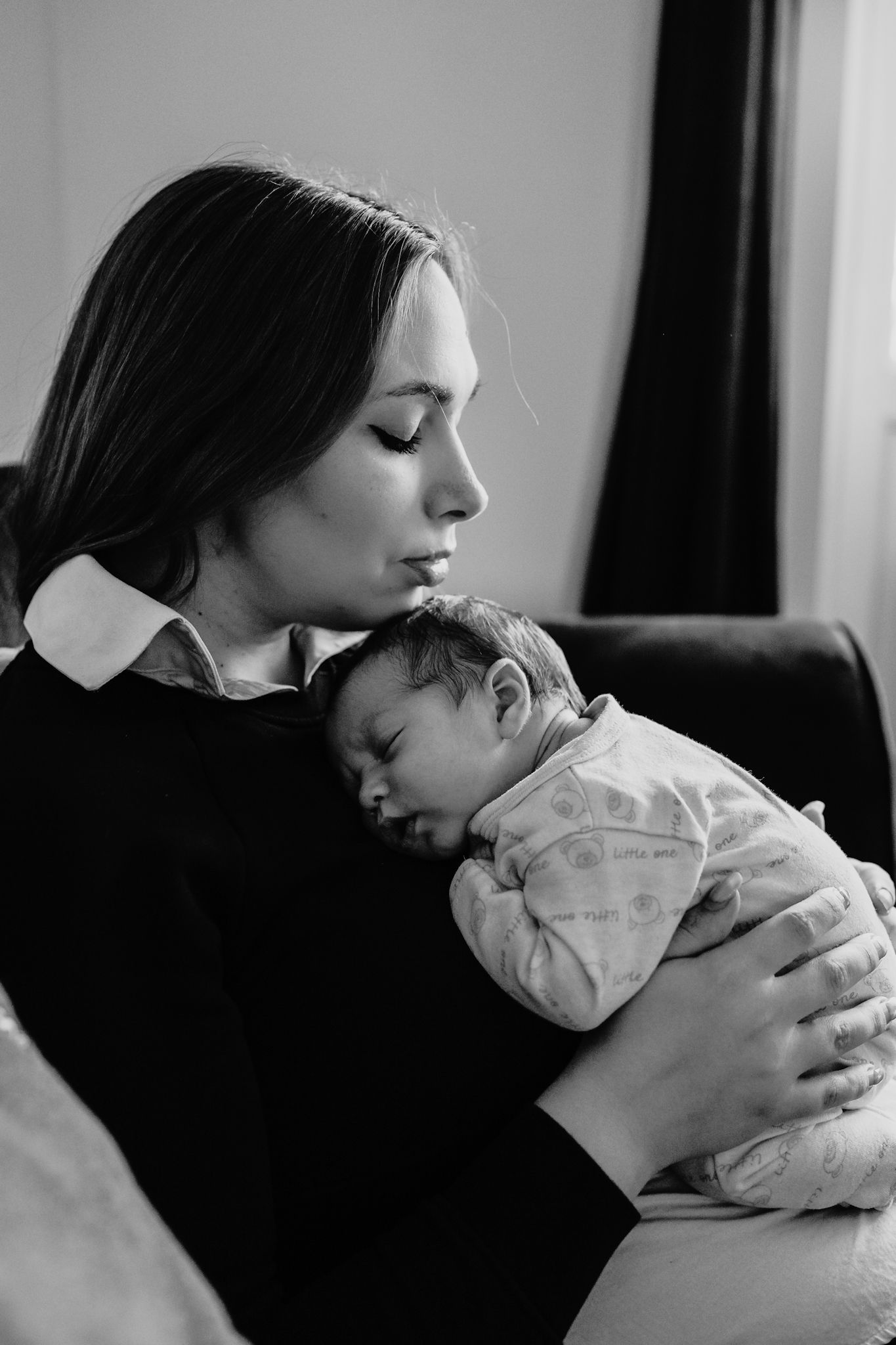 Mother-cuddles-her-baby-boy-at-home-newborn-photography