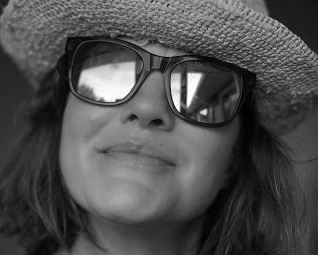 Black and white close-up of woman in hat with sunglasses smiling, outdoor portrait, North Vancouver