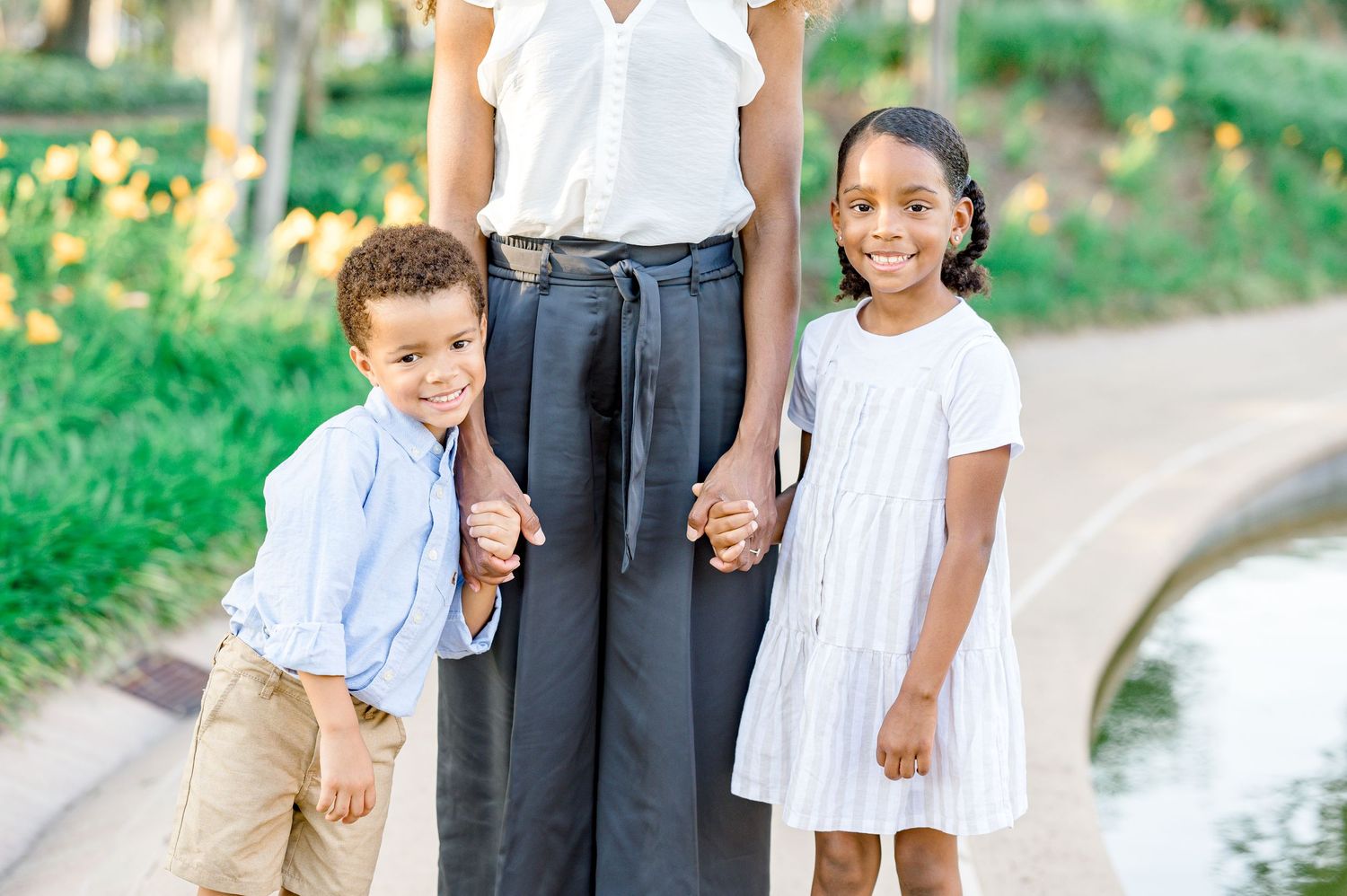 toddler and a little girl posing for family portraits at a park in bellaire in the spring