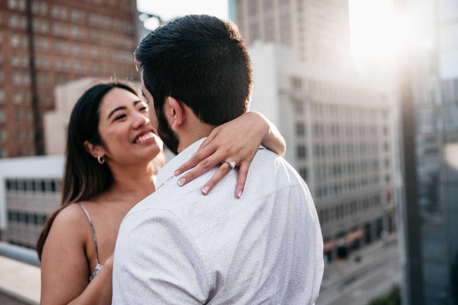 A joyful embrace captured against an urban backdrop of brick buildings.