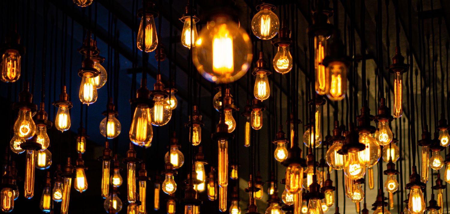 Vintage Edison bulbs hanging from ceiling create warm atmospheric lighting.