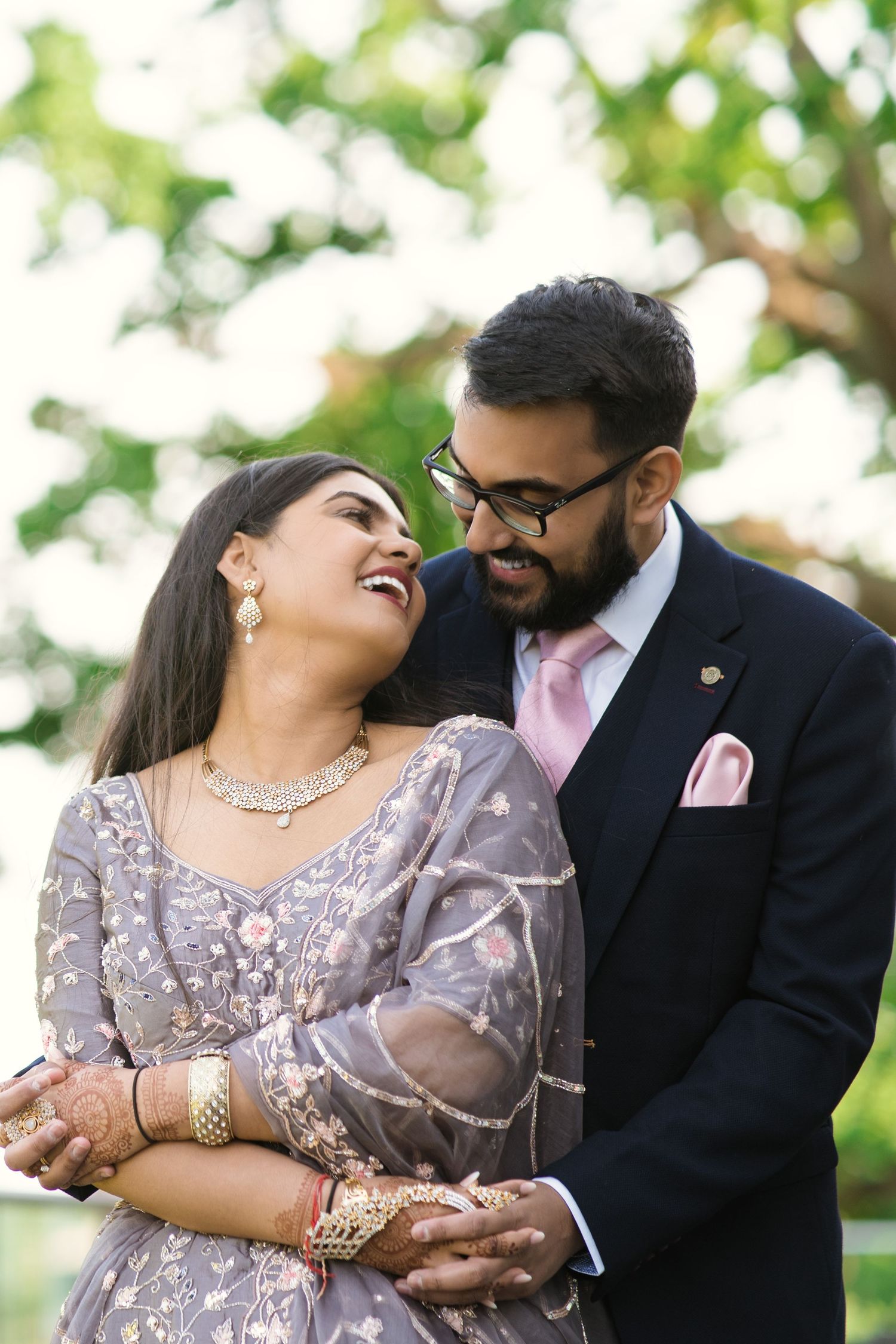 intimate newly weds holding each other and smiling  showing their love towards the camera