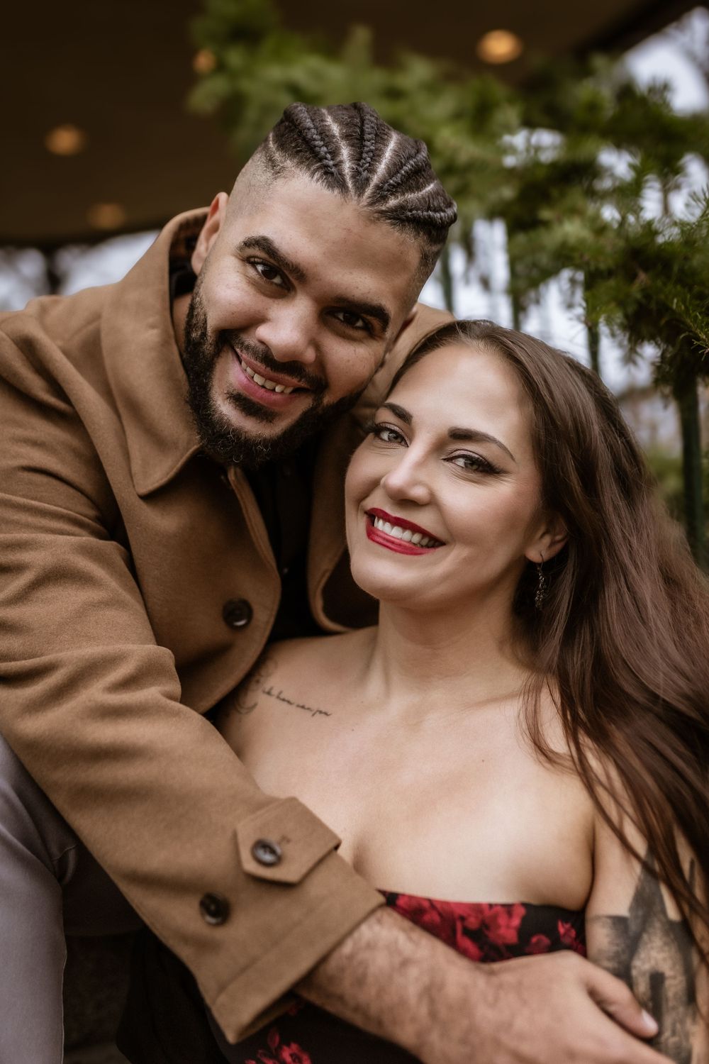 Affectionate couple in casual winter attire smiling warmly at camera.