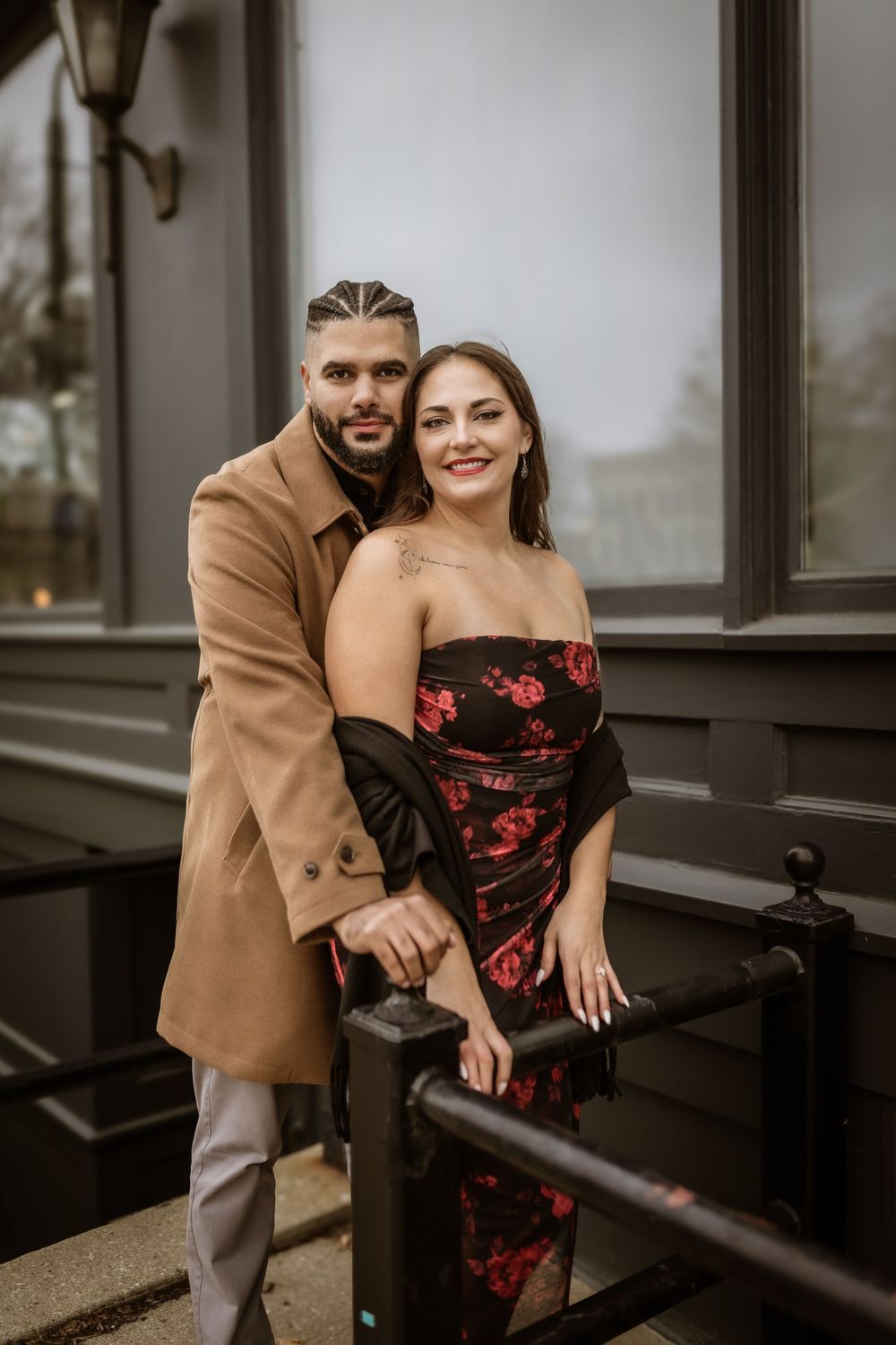 Fashionable couple posing on vintage building steps in urban setting.