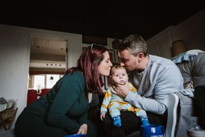 Family shares an intimate moment together in their living room, showing warmth and connection.