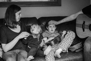 Black and white photo series showing intimate family moments at home with a baby and parents.
