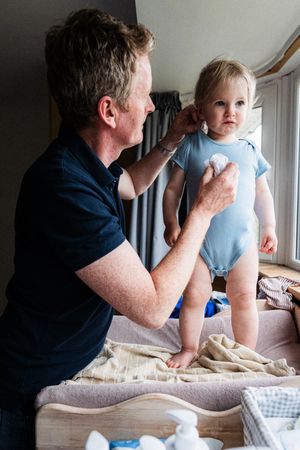 A sequence of photos shows a parent and young child sharing a tender moment on a bed with white linens.