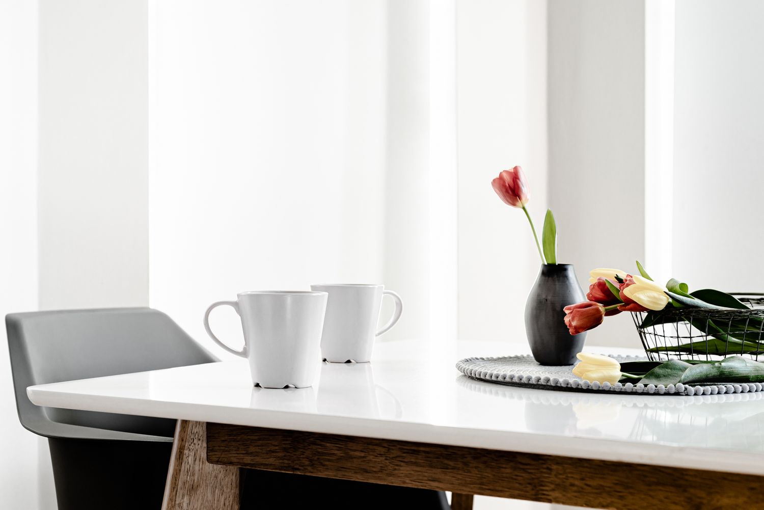 breakfast table with tulips and coffee mugs, inviting real estate photography