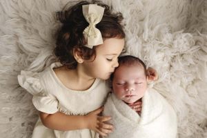 big sister kissing baby newborn session