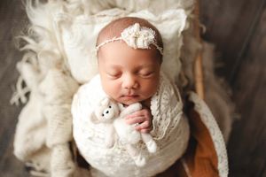baby holding bear in basket